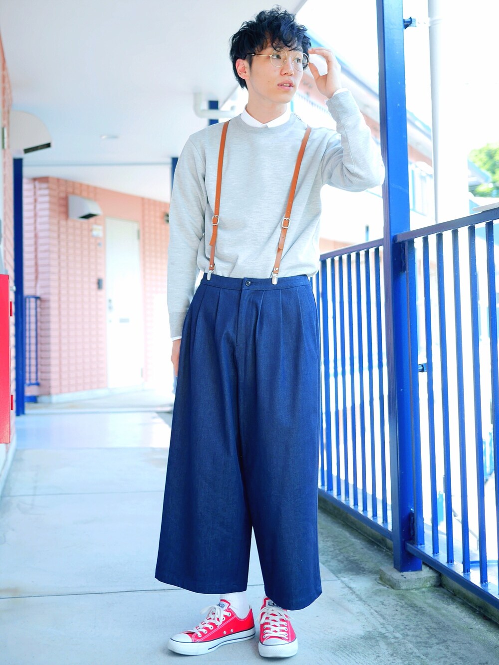 ブルー系のデニムパンツ、グレー系のTシャツ/カットソー、レッド系のスニーカーを着用したメンズの春コーディネートの1枚目の写真