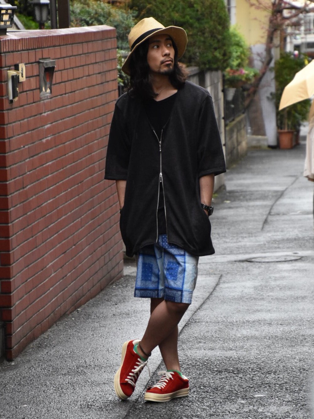 レッド系のスニーカー、ブラック系のカーディガン/ボレロ、ブルー系のその他パンツを着用したメンズの春コーディネートの1枚目の写真