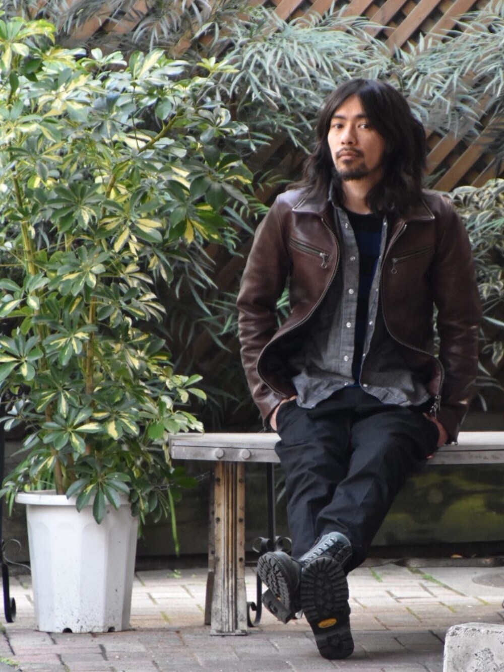 ブラック系のニット/セーター、ブラック系のパンツ、ブラウン系のライダースジャケットを着用したメンズの春コーディネートの1枚目の写真