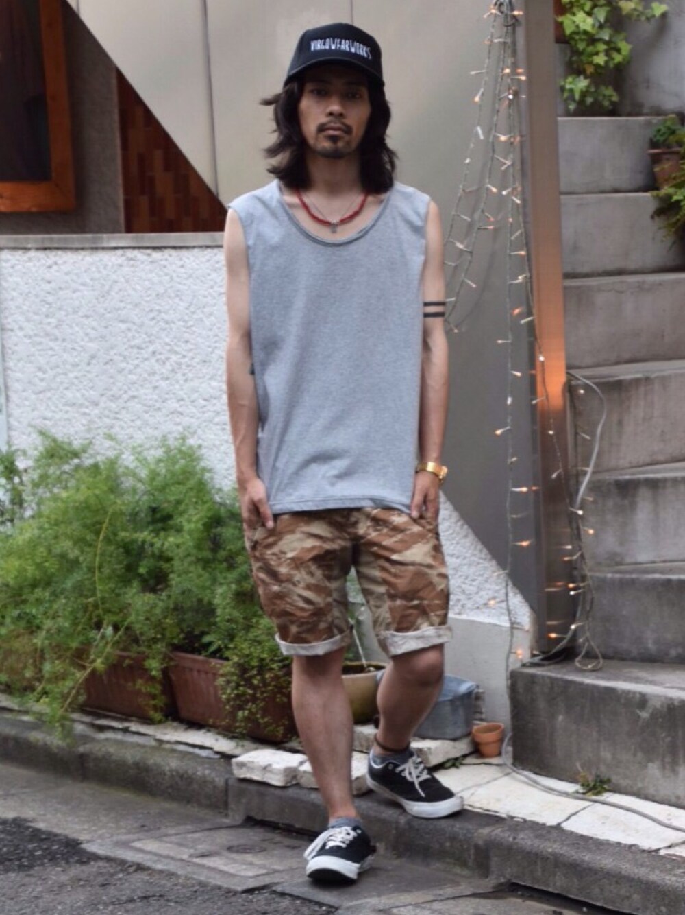 グレー系のTシャツ/カットソー、ベージュ系のスラックス、ブラック系のスニーカーを着用したメンズの夏コーディネートの1枚目の写真