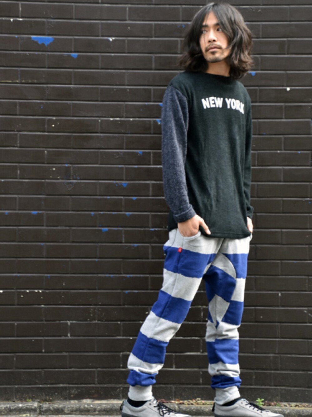 ブルー系のニット/セーター、ブルー系のパンツ、グレー系のスニーカーを着用したメンズの春コーディネートの1枚目の写真