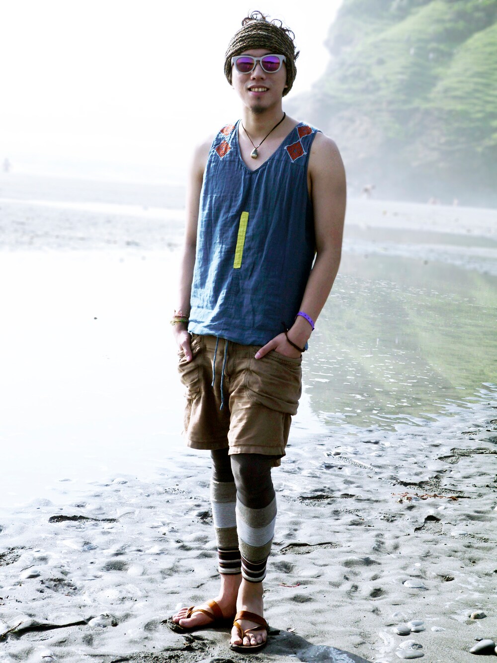 ブルー系のタンクトップ、ブラウン系のヘアバンドを着用したメンズの春コーディネートの1枚目の写真