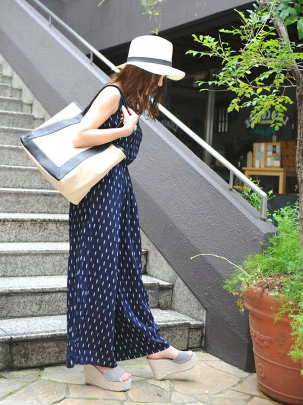 ベージュ系のトートバッグ、グレー系のサンダル、ホワイト系のハットを着用したレディースの秋コーディネートの1枚目の写真