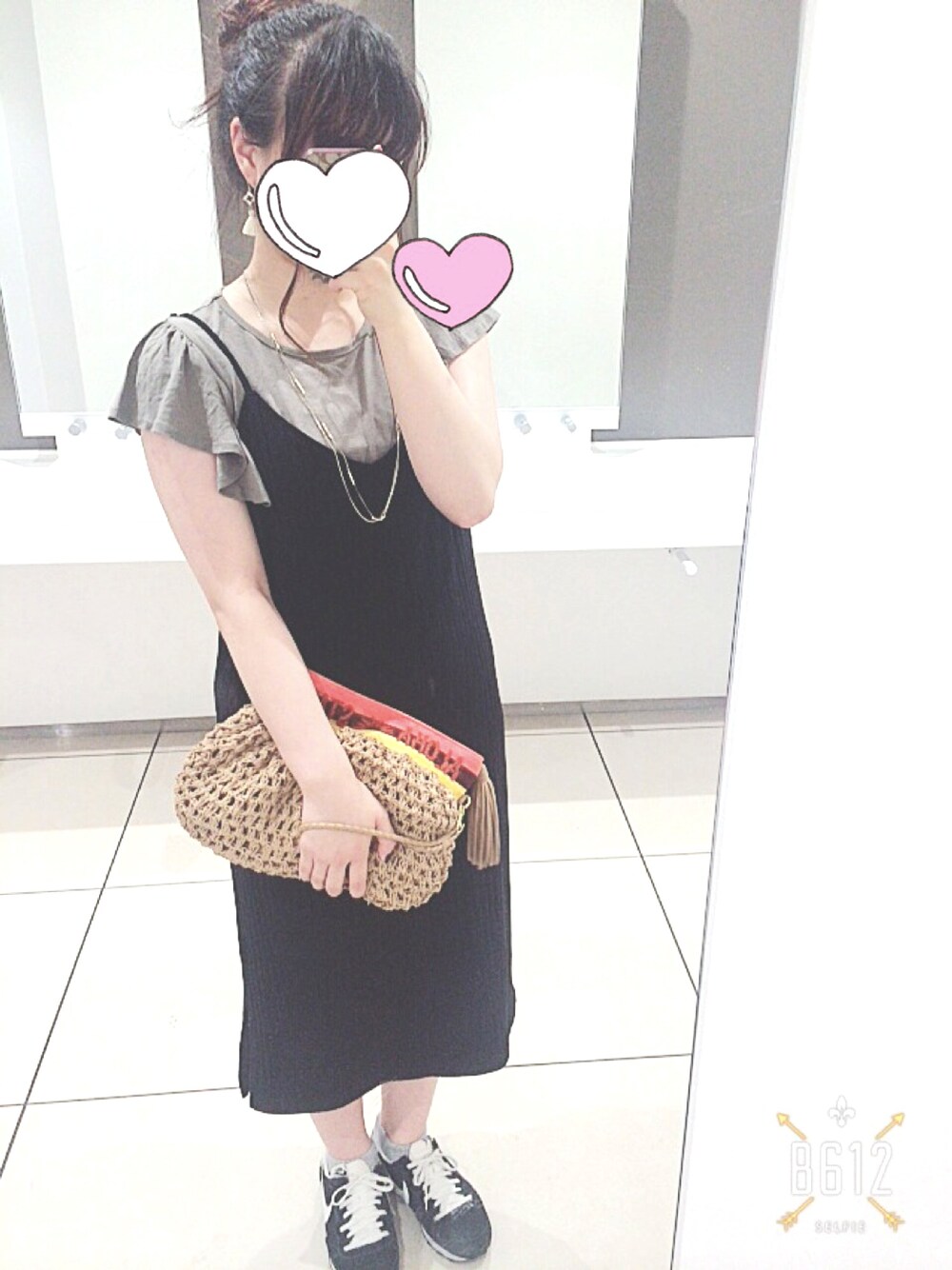 グリーン系のTシャツ/カットソー、ベージュ系のクラッチバッグ、ブラック系のスニーカーを着用したレディースの夏コーディネートの1枚目の写真