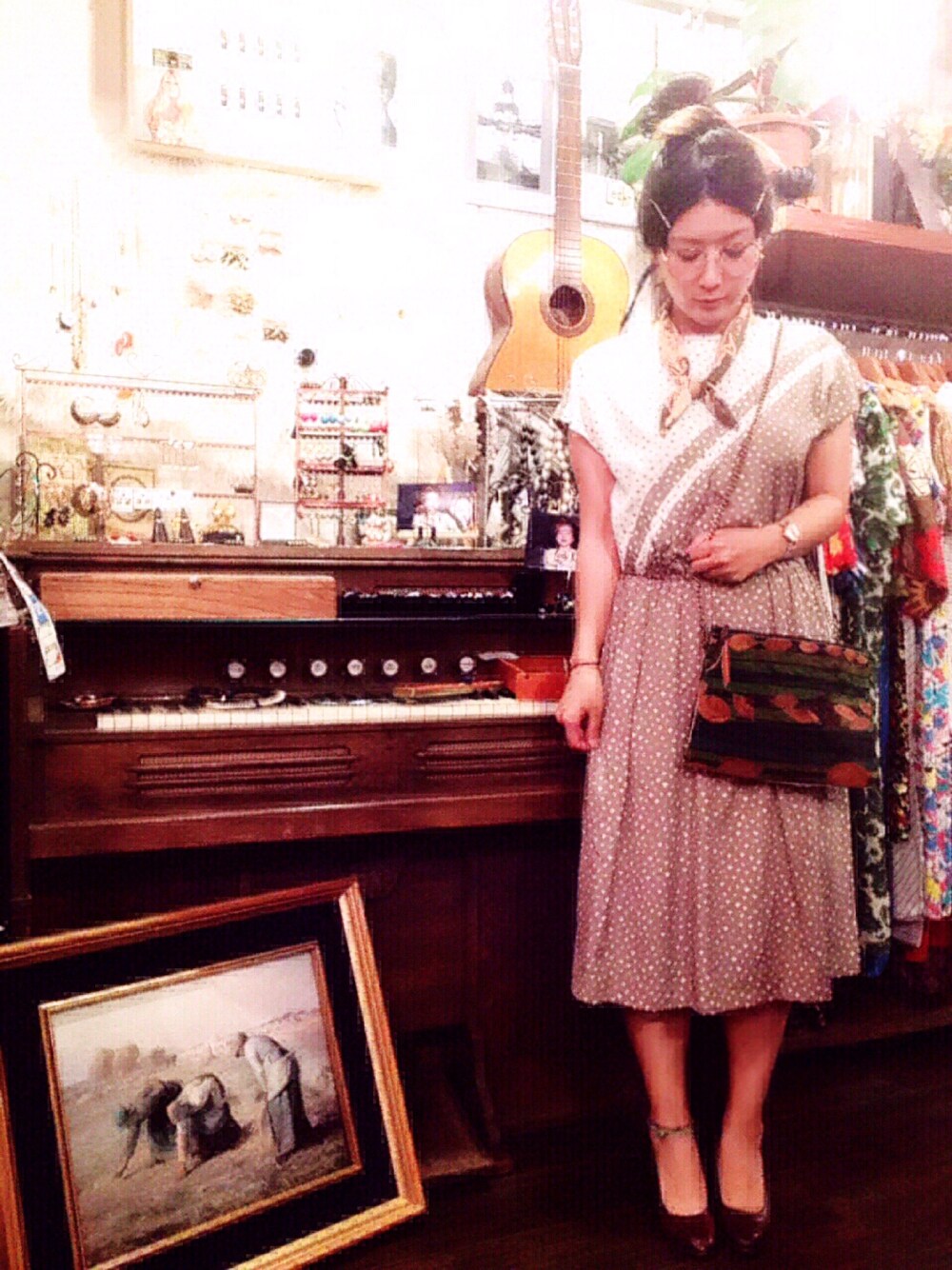 ベージュ系のワンピース、グリーン系のショルダーバッグ、ブラウン系のパンプスを着用したレディースの春コーディネートの1枚目の写真