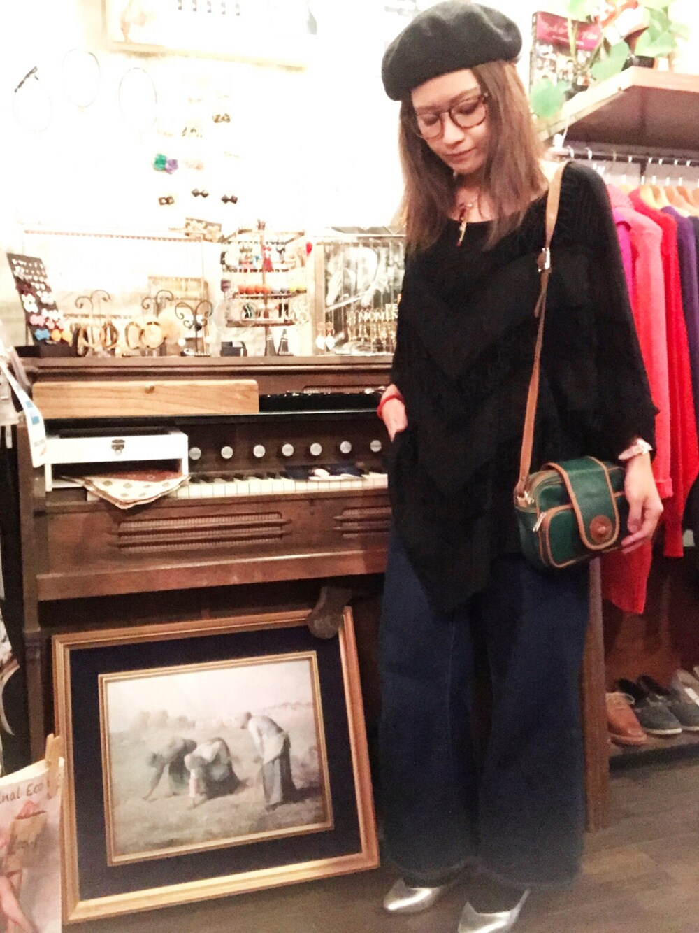 ブラック系のトップス、グリーン系のショルダーバッグ、シルバー系のシューズを着用したレディースの冬コーディネートの1枚目の写真