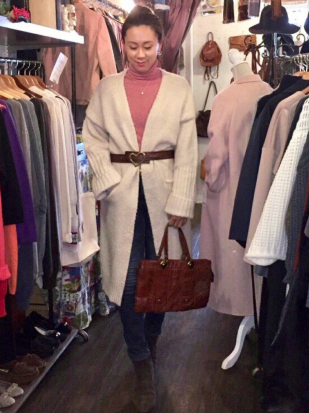 ホワイト系のその他アウター、ブラウン系のハンドバッグ、ゴールド系のピアス(両耳用)を着用したレディースの冬コーディネートの1枚目の写真