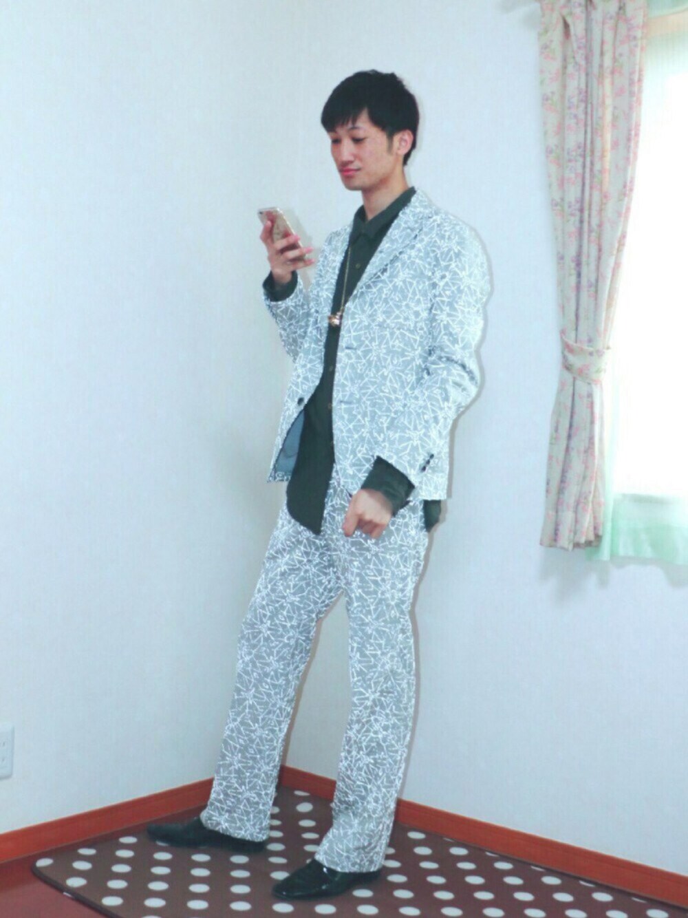 グレー系のテーラードジャケット、ブラック系のパンプス、グレー系のスラックスを着用したメンズの春コーディネートの1枚目の写真