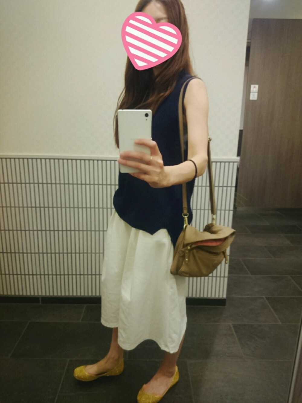ホワイト系のパンツ、ゴールド系のシューズ、ベージュ系のクラッチバッグを着用したレディースの夏コーディネートの1枚目の写真