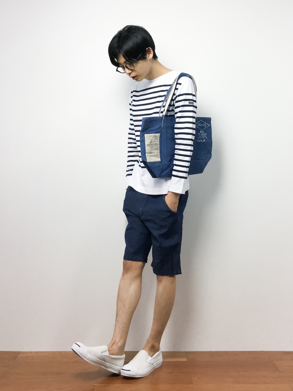 ホワイト系のTシャツ/カットソー、ブルー系のトートバッグ、ブルー系のデニムパンツを着用したメンズの夏コーディネートの1枚目の写真