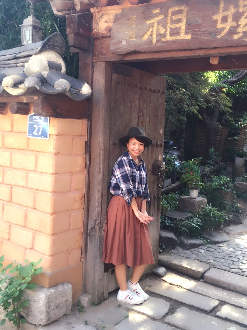 ブラウン系のスカート、ブルー系のシャツ/ブラウス、ホワイト系のスニーカーを着用したレディースの秋コーディネートの1枚目の写真