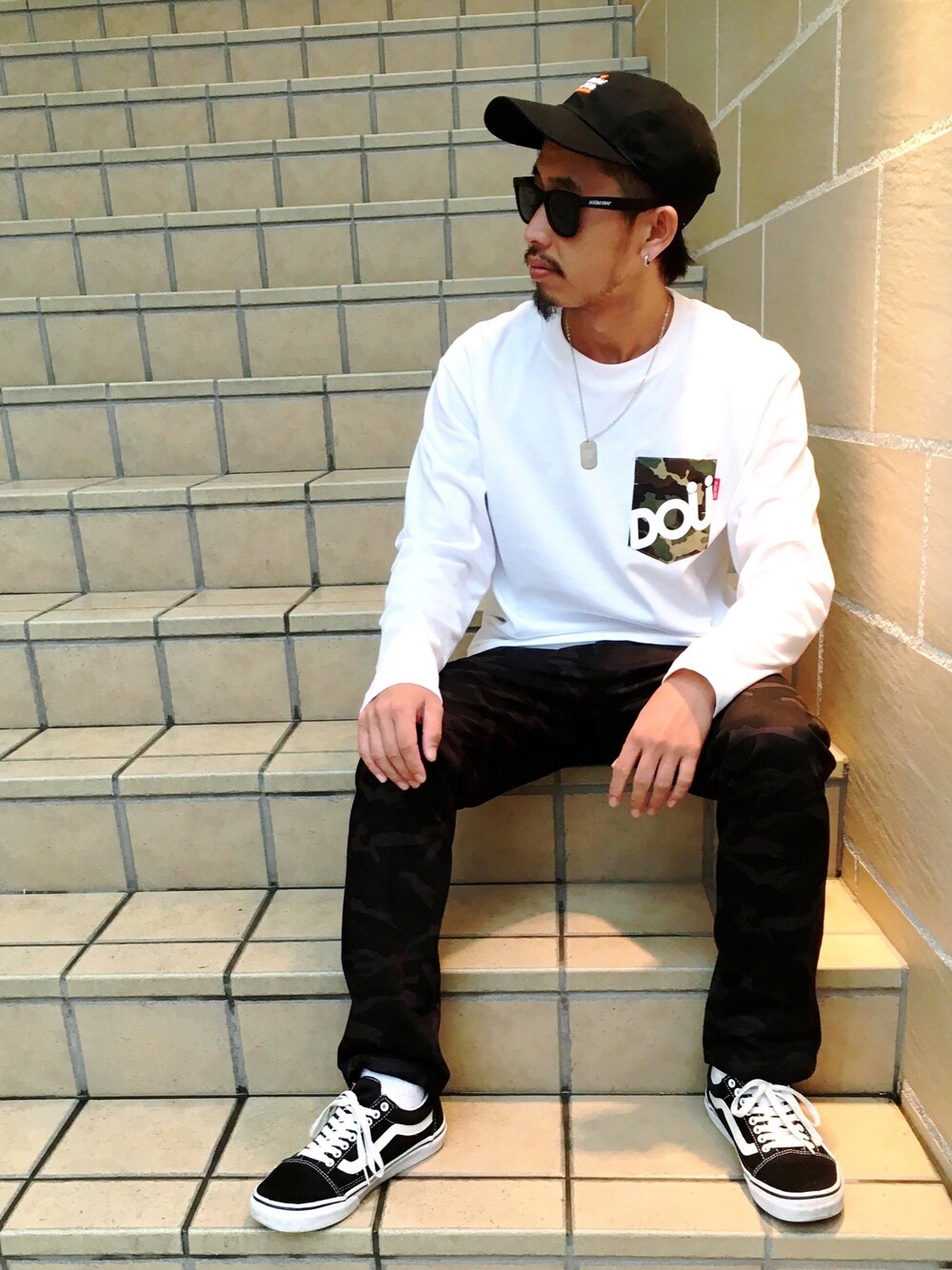 ホワイト系のTシャツ/カットソー、グレー系のチノパンツ、ブラック系のスニーカーを着用したメンズの秋コーディネートの1枚目の写真
