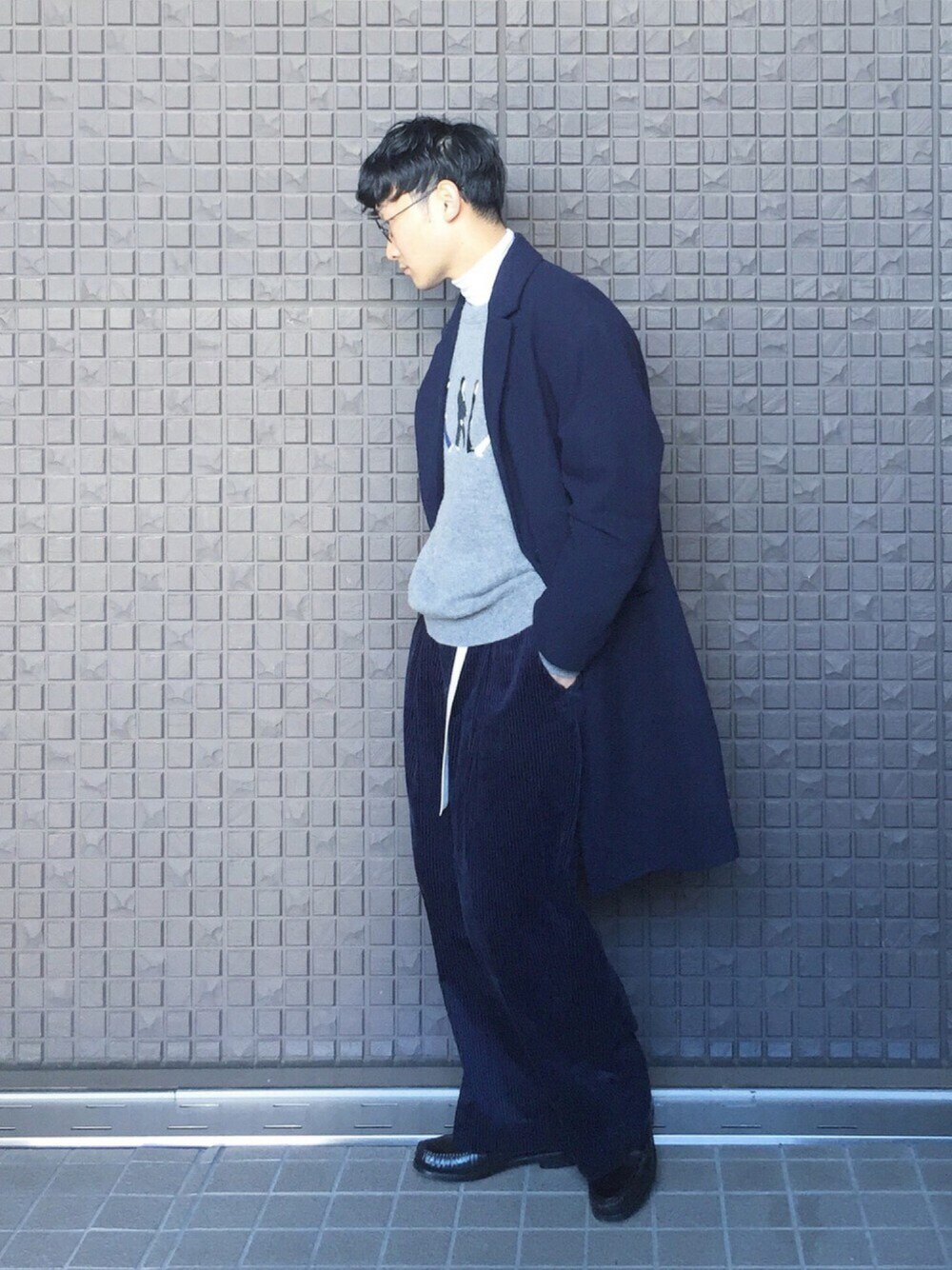 ブルー系のチェスターコート、グレー系のニット/セーター、ホワイト系のTシャツ/カットソーを着用したメンズの秋コーディネートの1枚目の写真