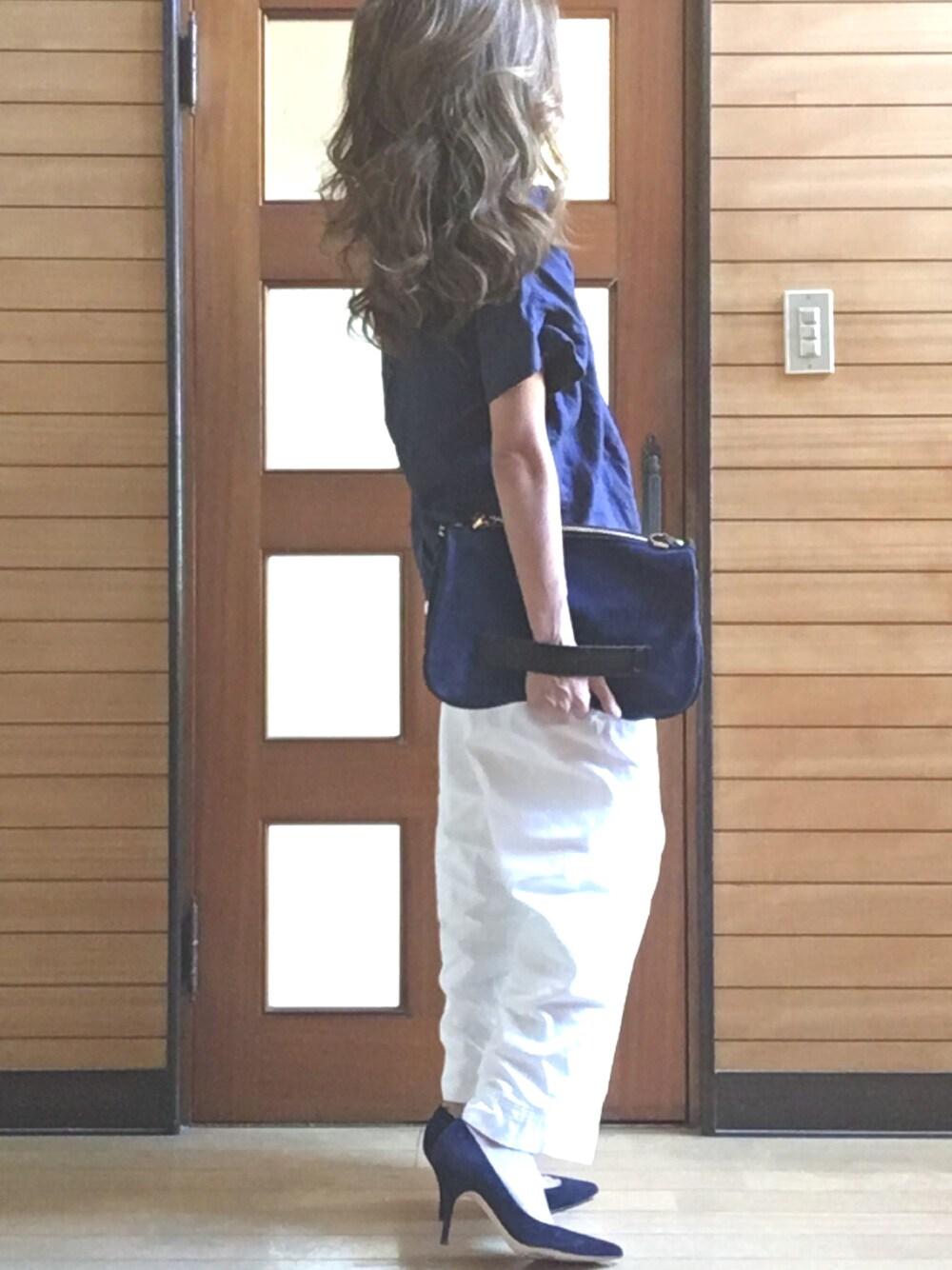 ブルー系のシャツ/ブラウス、ブルー系のクラッチバッグ、ホワイト系のパンツを着用したレディースの夏コーディネートの1枚目の写真