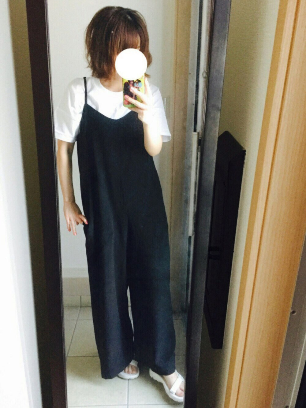 ホワイト系のTシャツ/カットソー、ブラック系のつなぎ/オールインワン、ホワイト系のサンダルを着用したレディースの春コーディネートの1枚目の写真