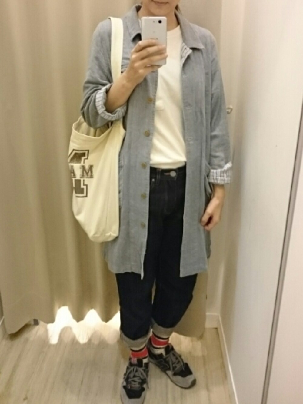 グリーン系のショルダーバッグ、スニーカー、ブルー系のデニムパンツを着用したレディースの春コーディネートの1枚目の写真