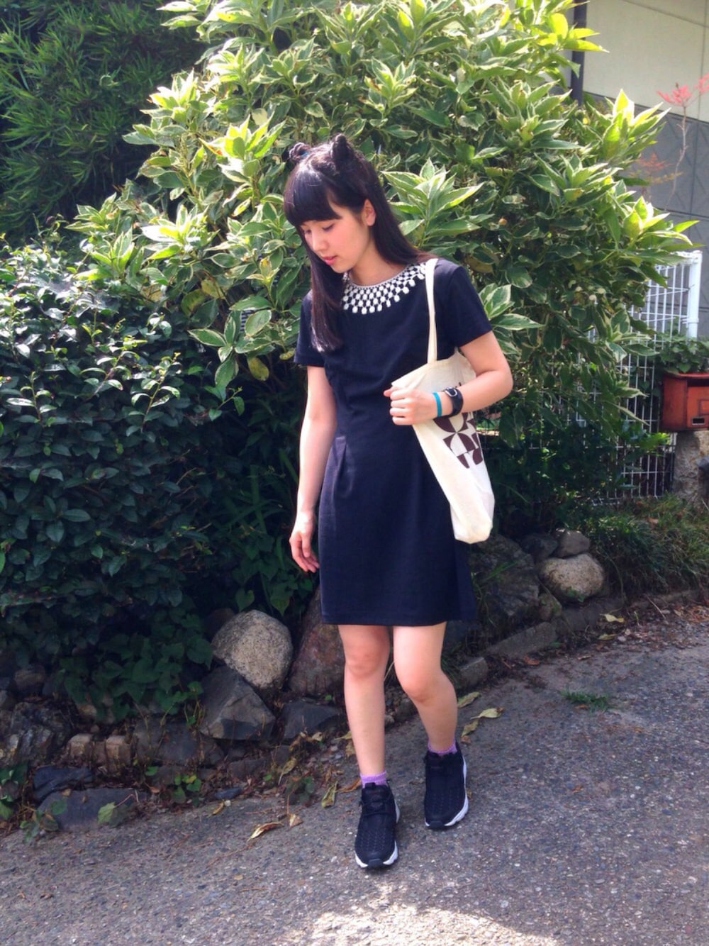 ブラック系のワンピース、ベージュ系のトートバッグ、ブラック系のスニーカーを着用したレディースの夏コーディネートの1枚目の写真