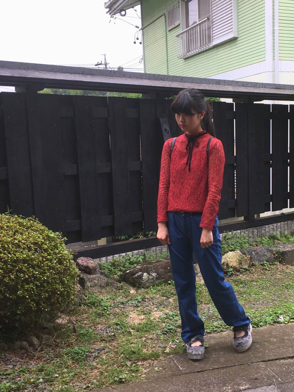 レッド系のTシャツ/カットソー、ブラック系のバッグ、ブルー系のデニムパンツを着用したレディースの秋コーディネートの1枚目の写真