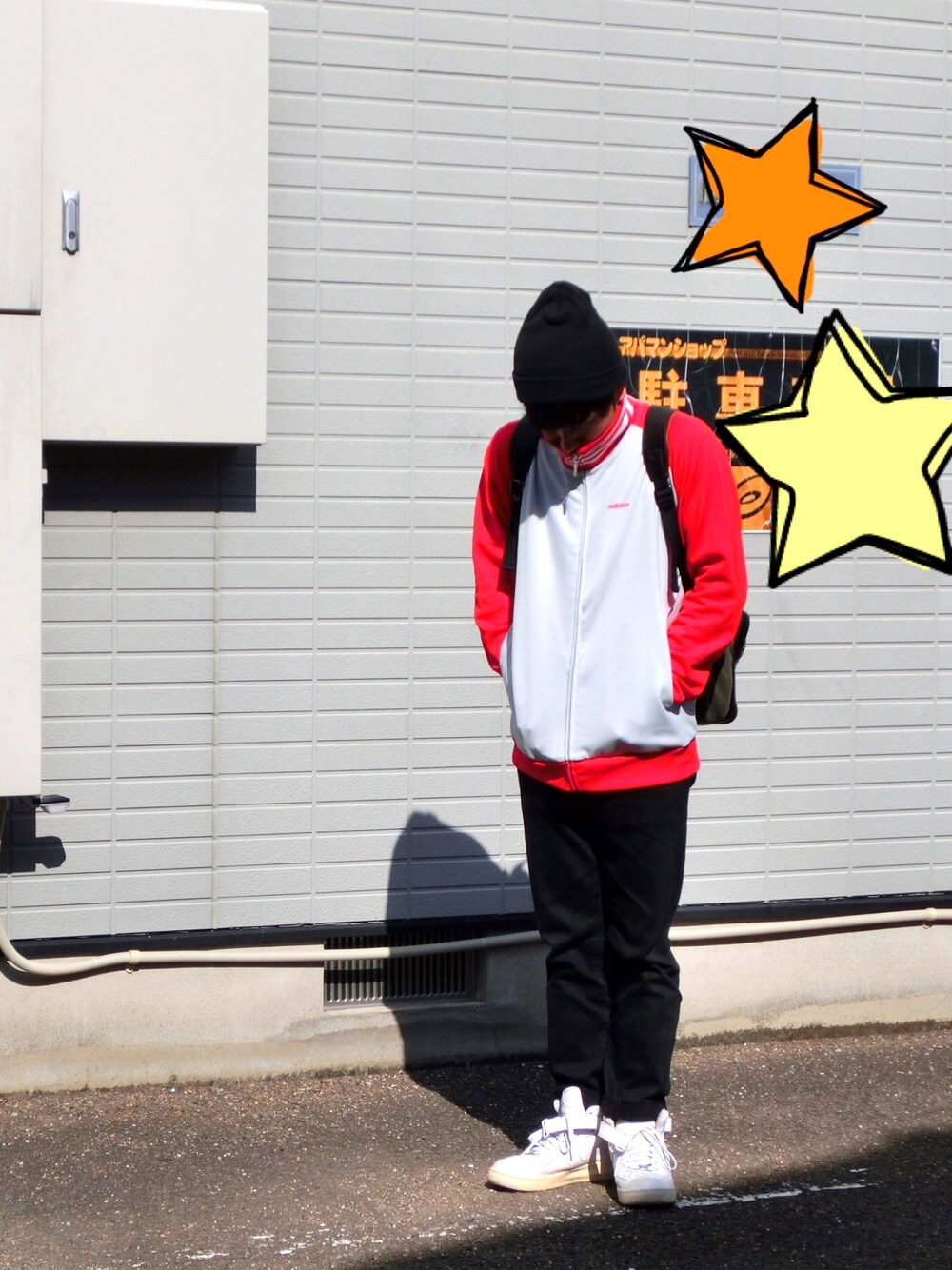 レッド系のジャージ、ブラック系のデニムパンツ、ホワイト系のスニーカーを着用したメンズの秋コーディネートの1枚目の写真