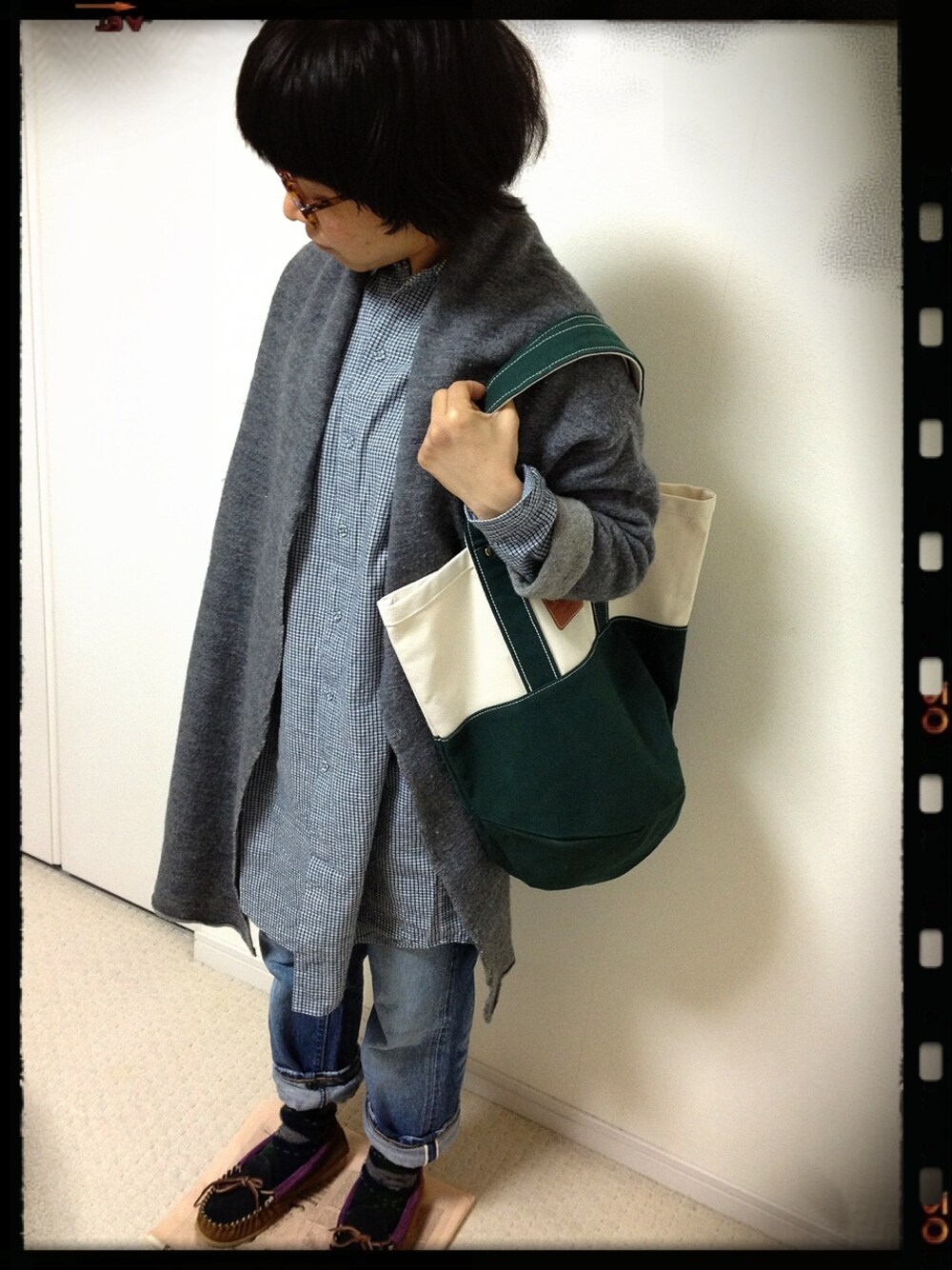 ブルー系のデニムパンツ、ブルー系のモカシン/デッキシューズ、グリーン系のトートバッグを着用したレディースの春コーディネートの1枚目の写真