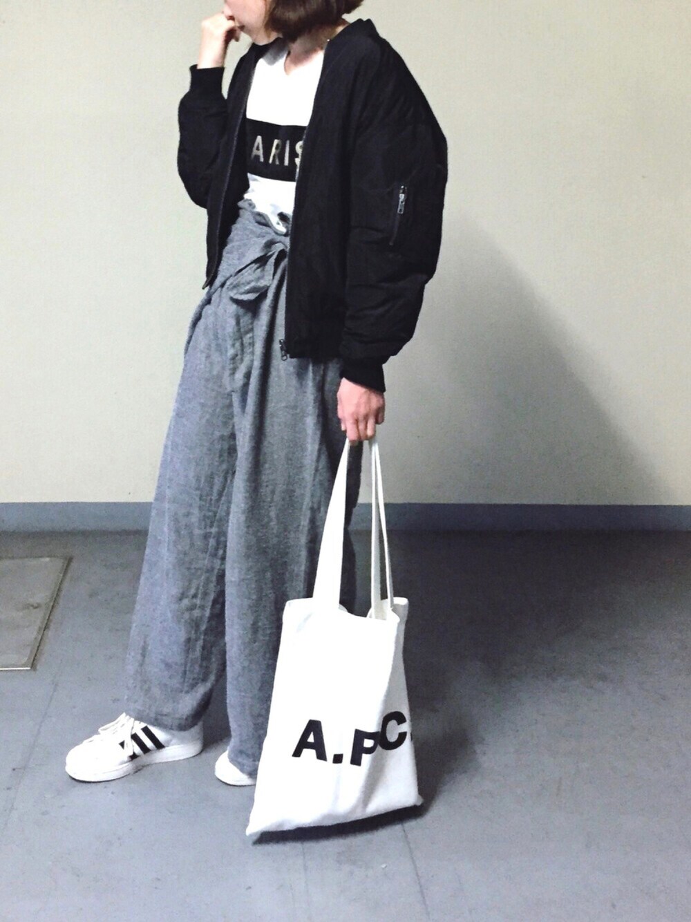 グレー系のその他パンツ、ブラック系のブルゾン、ホワイト系のトートバッグを着用したレディースの冬コーディネートの1枚目の写真