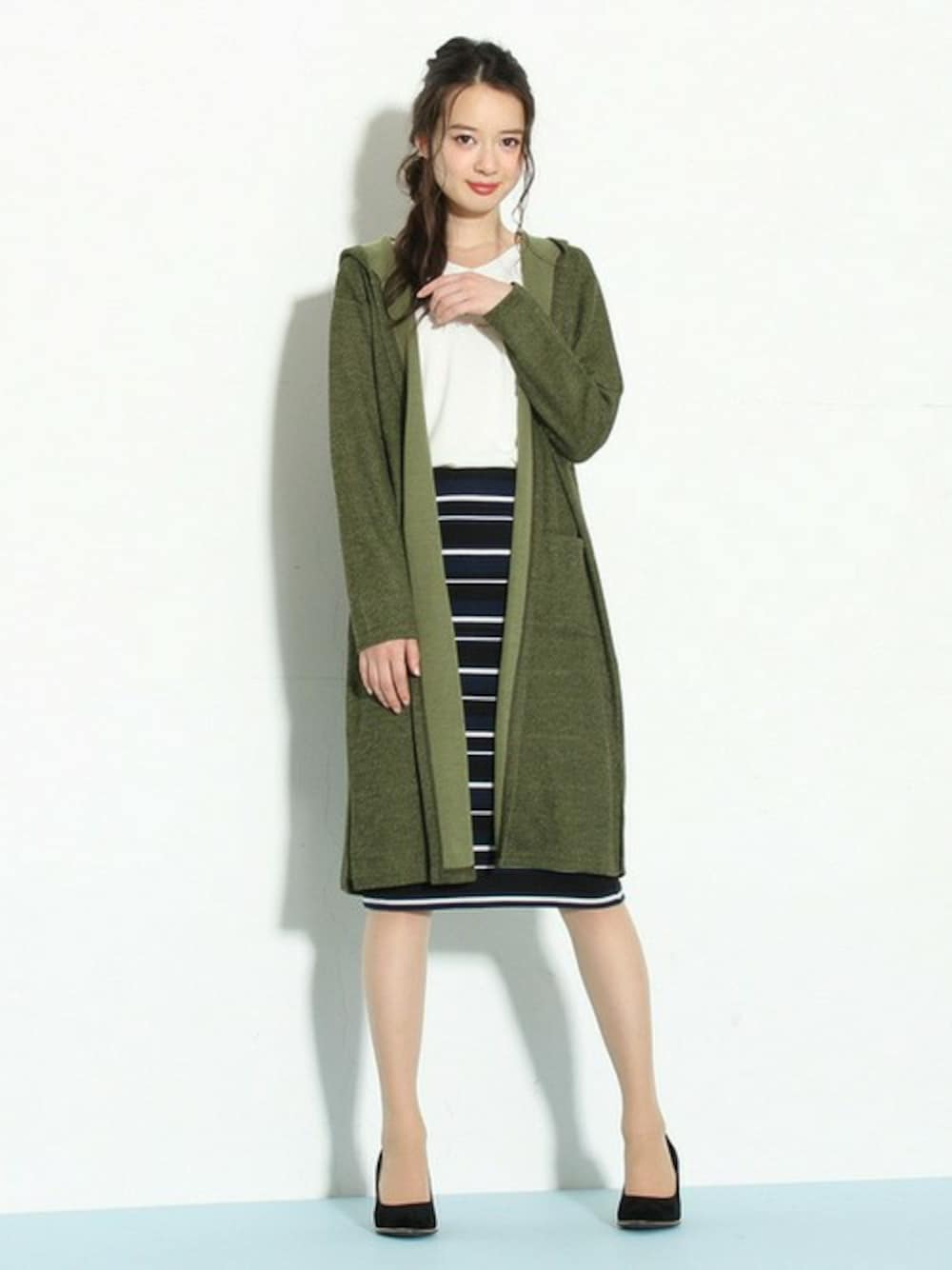 グリーン系のトップス、ホワイト系のトップス、ブルー系のスカートを着用したレディースの秋コーディネートの1枚目の写真