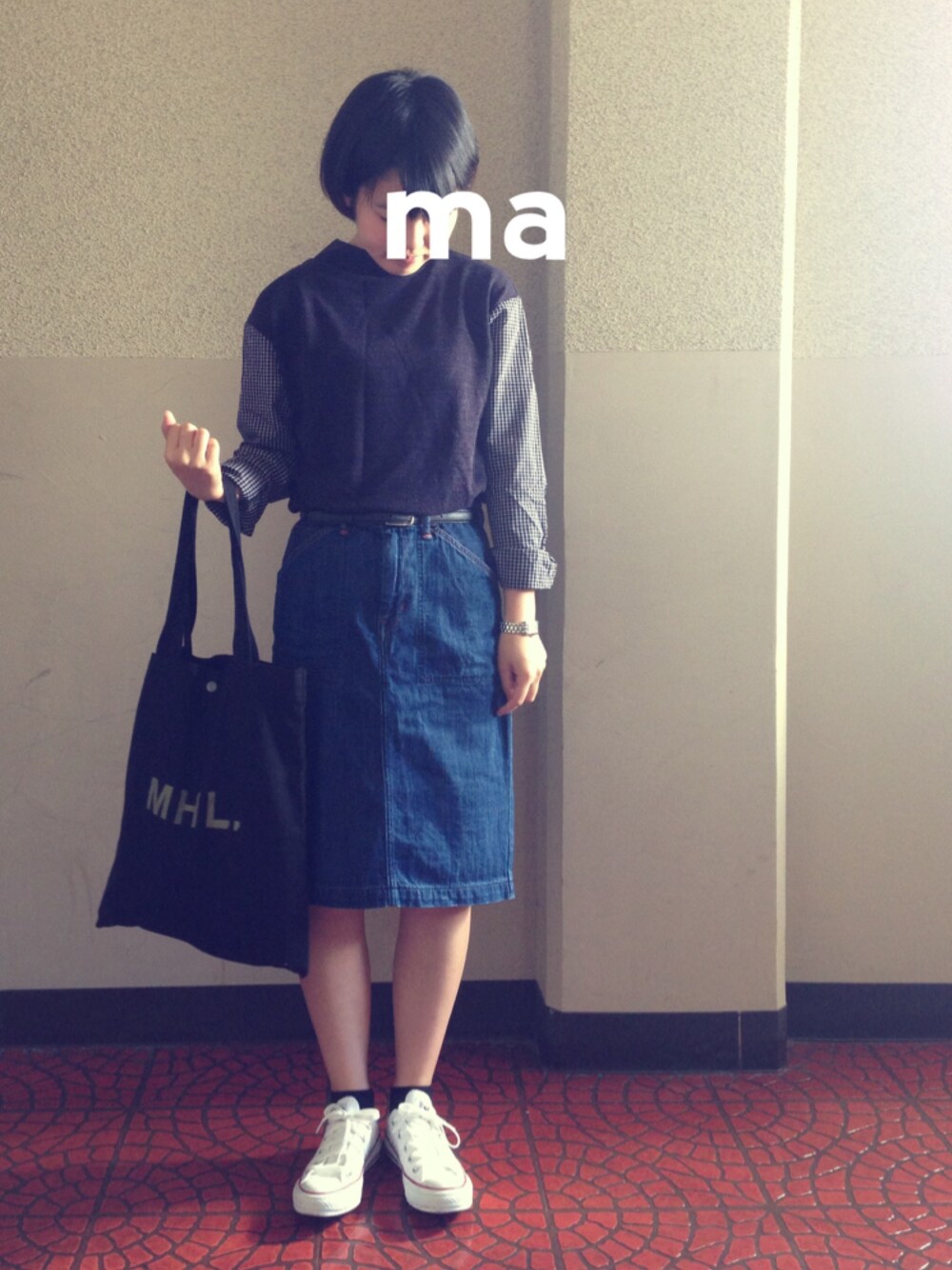 ブルー系のデニムスカート、ブラック系のトートバッグ、ホワイト系のスニーカーを着用したレディースの秋コーディネートの1枚目の写真
