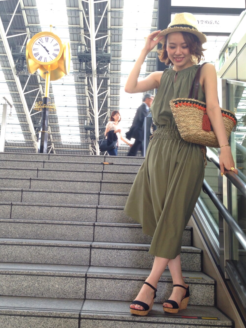 グリーン系のワンピース、その他のかごバッグ、ブラック系のサンダルを着用したレディースの夏コーディネートの1枚目の写真