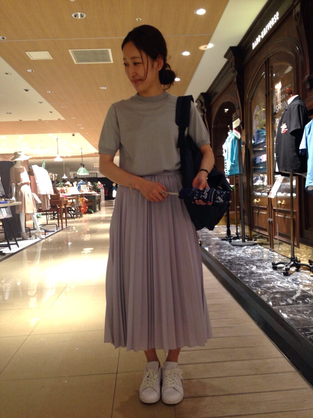 グレー系のスカート、グレー系のニット/セーター、ブルー系のバックパック/リュックを着用したレディースの夏コーディネートの1枚目の写真