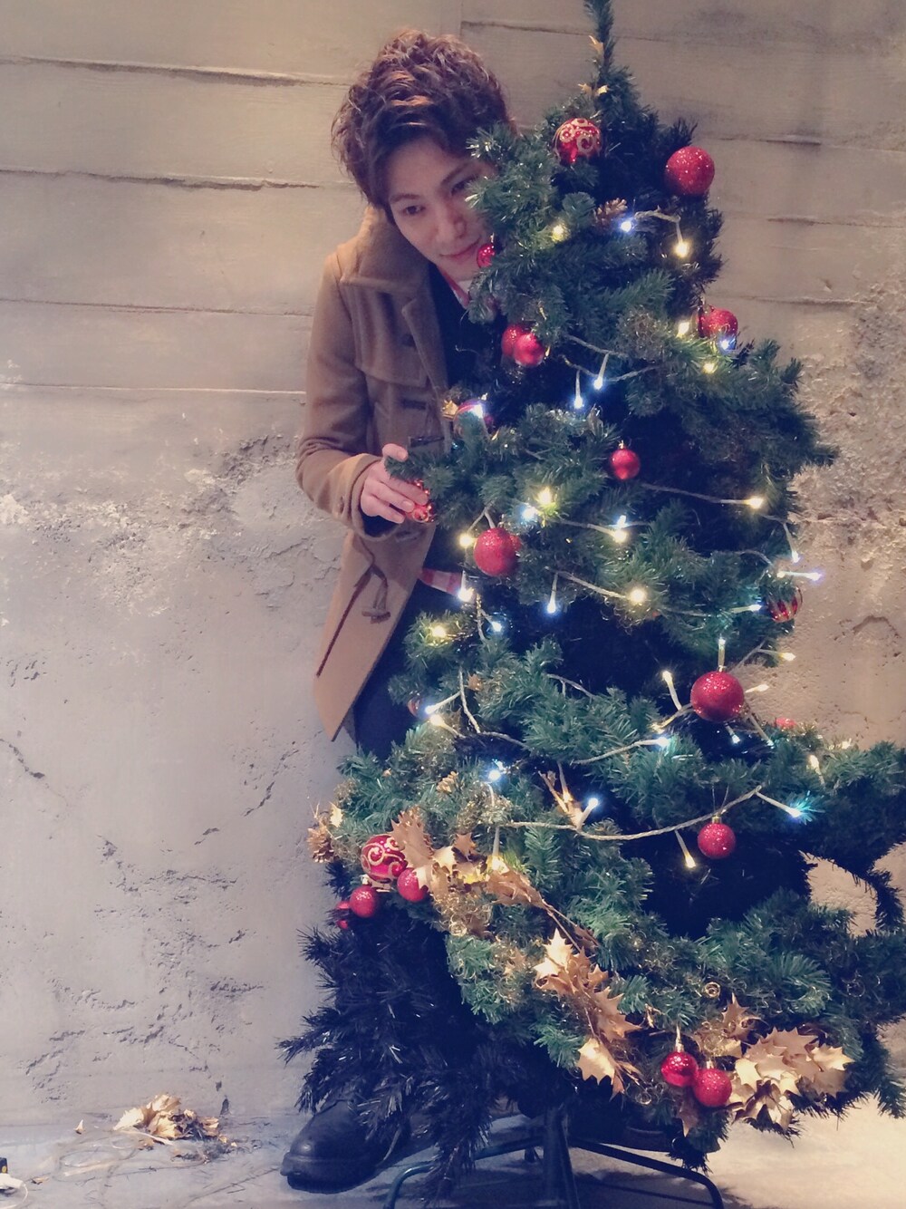 ベージュ系のダッフルコート、レッド系のシャツ/ブラウス、ブラック系のニット/セーターを着用したメンズの秋コーディネートの1枚目の写真