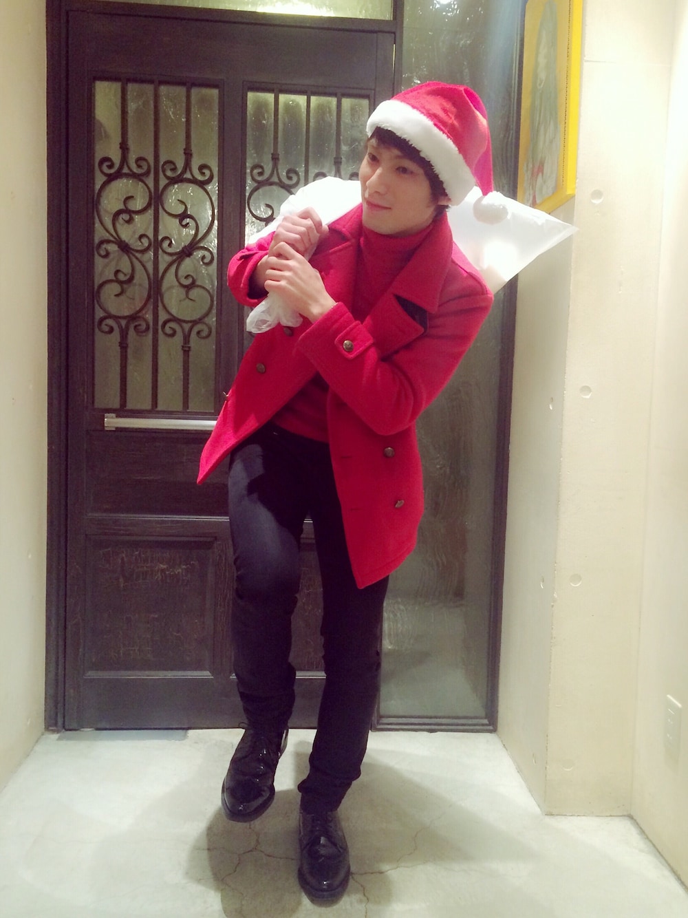 レッド系のニット/セーター、レッド系のピーコート、ブラック系のTシャツ/カットソーを着用したメンズの冬コーディネートの1枚目の写真