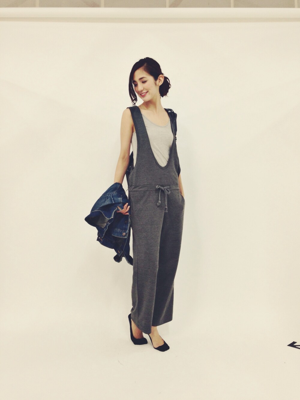 「オールグレー、サロペット、リュック、撮影、お団子ヘアー、デニムジャケット、plainclothing、PORTER」｜「PLAIN CLOTHINGの【PLAIN CLOTHING】サロペット（その他パンツ、グレー系）」を使った、片桐ゆたかさん（レディース・172cm）の秋コーディネートの1枚目の写真