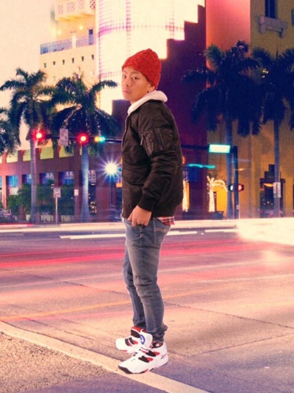 ホワイト系のスニーカー、ブラック系のナイロンジャケット、レッド系のシャツ/ブラウスを着用したメンズの冬コーディネートの1枚目の写真