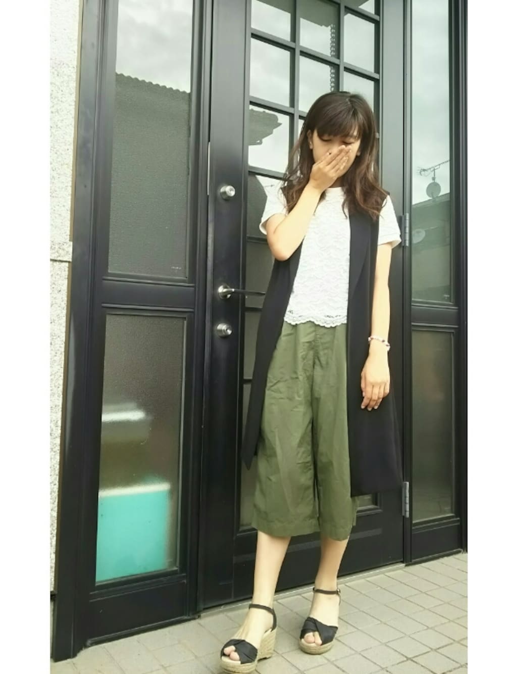 イエロー系のショルダーバッグ、ホワイト系のTシャツ/カットソー、ブラック系のサンダルを着用したレディースの夏コーディネートの1枚目の写真