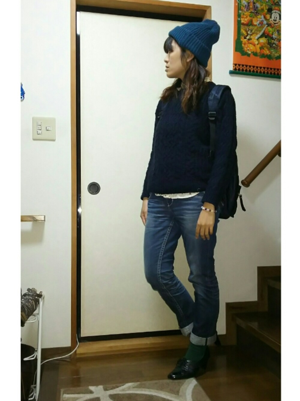 ブルー系のデニムパンツ、ブルー系のバックパック/リュック、ブルー系のニット/セーターを着用したレディースの秋コーディネートの1枚目の写真