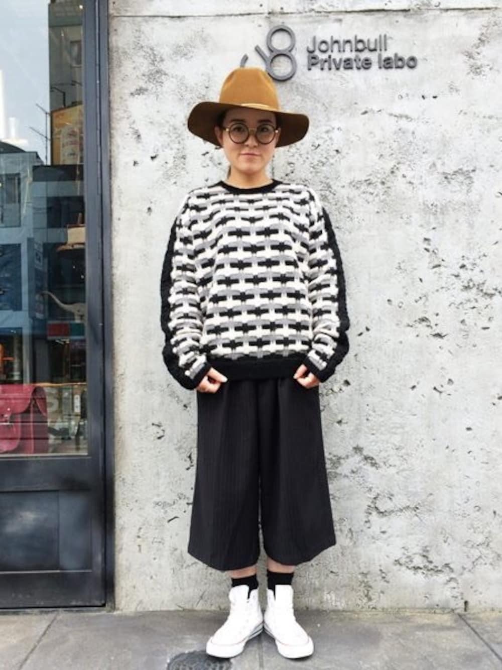 ブラック系のスラックス、ブラウン系のハットを着用したレディースの冬コーディネートの1枚目の写真