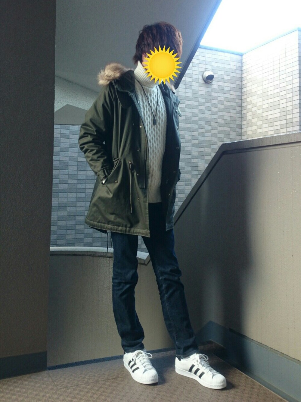 ホワイト系のスニーカー、グリーン系のモッズコート、ブラウン系のアナログ腕時計を着用したメンズの冬コーディネートの1枚目の写真