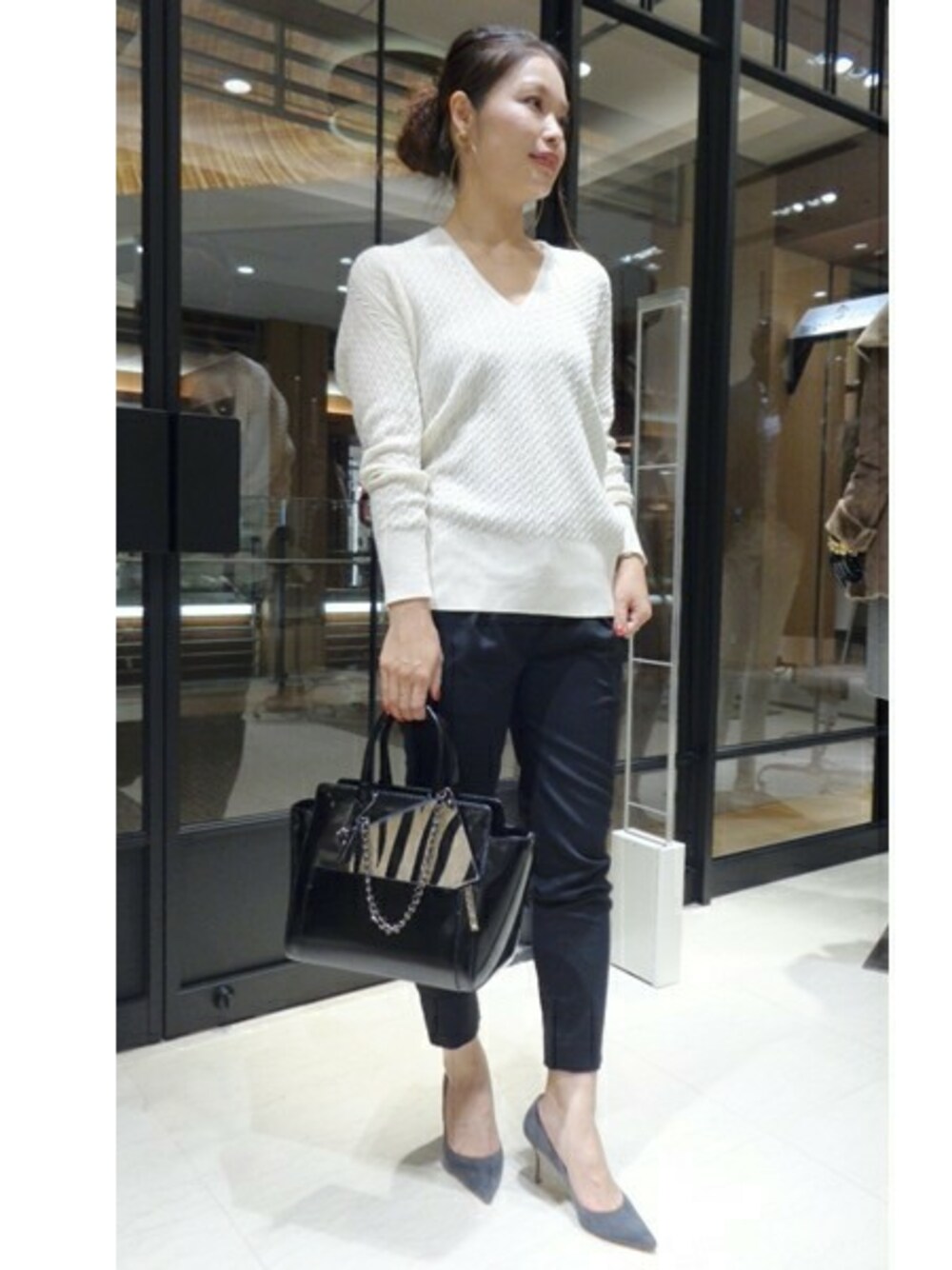 ホワイト系のニット/セーター、ブラウン系のショルダーバッグを着用したレディースの秋コーディネートの1枚目の写真