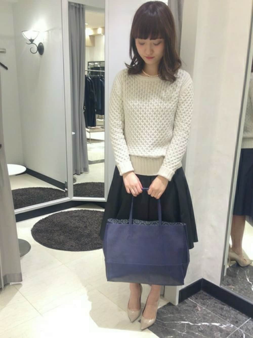 ブラック系のスカート、ブルー系のトートバッグを着用したレディースの冬コーディネートの1枚目の写真