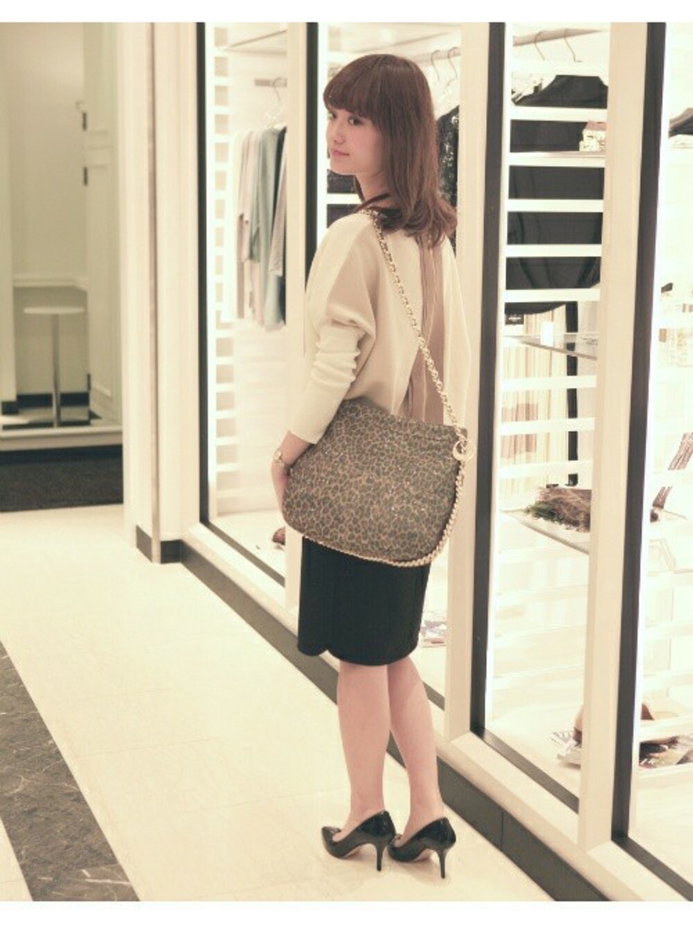 ベージュ系のショルダーバッグ、ホワイト系のニット/セーター、ブラック系のスカートを着用したレディースの冬コーディネートの1枚目の写真