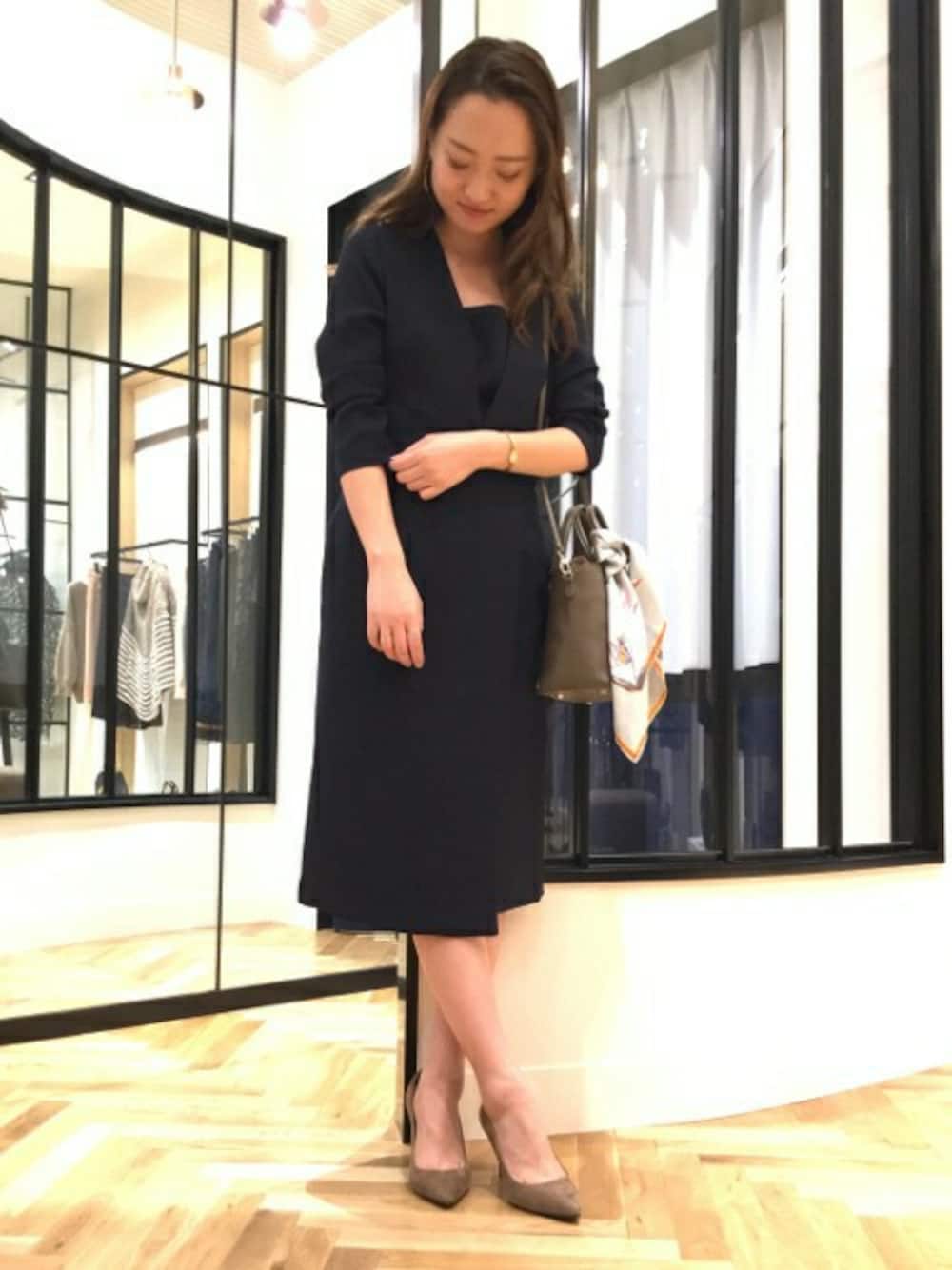 ブルー系のワンピース、ブラウン系のパンプス、ブラウン系のショルダーバッグを着用したレディースの秋コーディネートの1枚目の写真