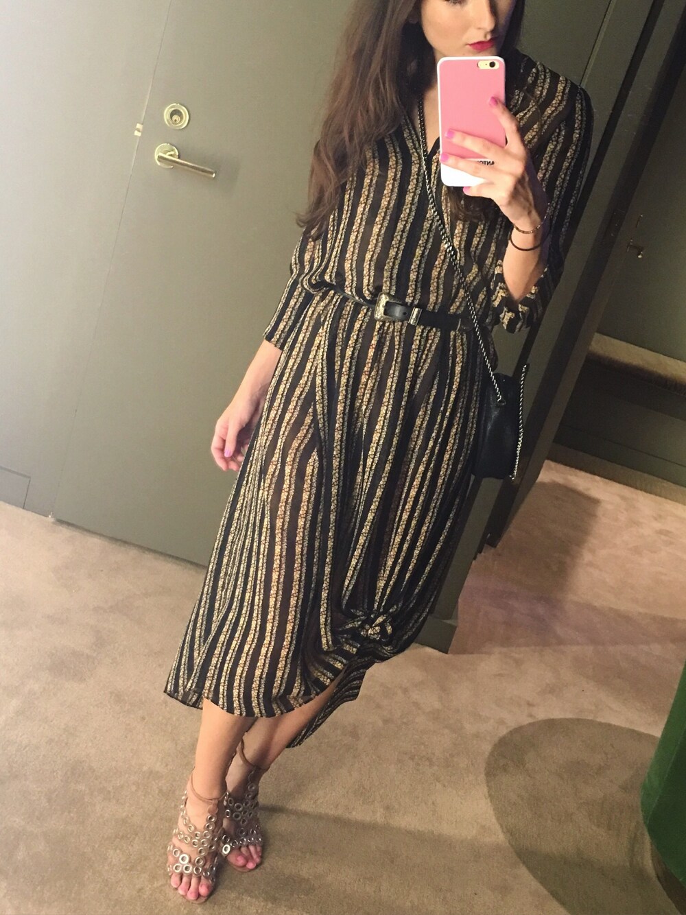 ブラック系のドレス、ベージュ系のサンダル、ブラック系のショルダーバッグを着用したレディースの秋コーディネートの1枚目の写真