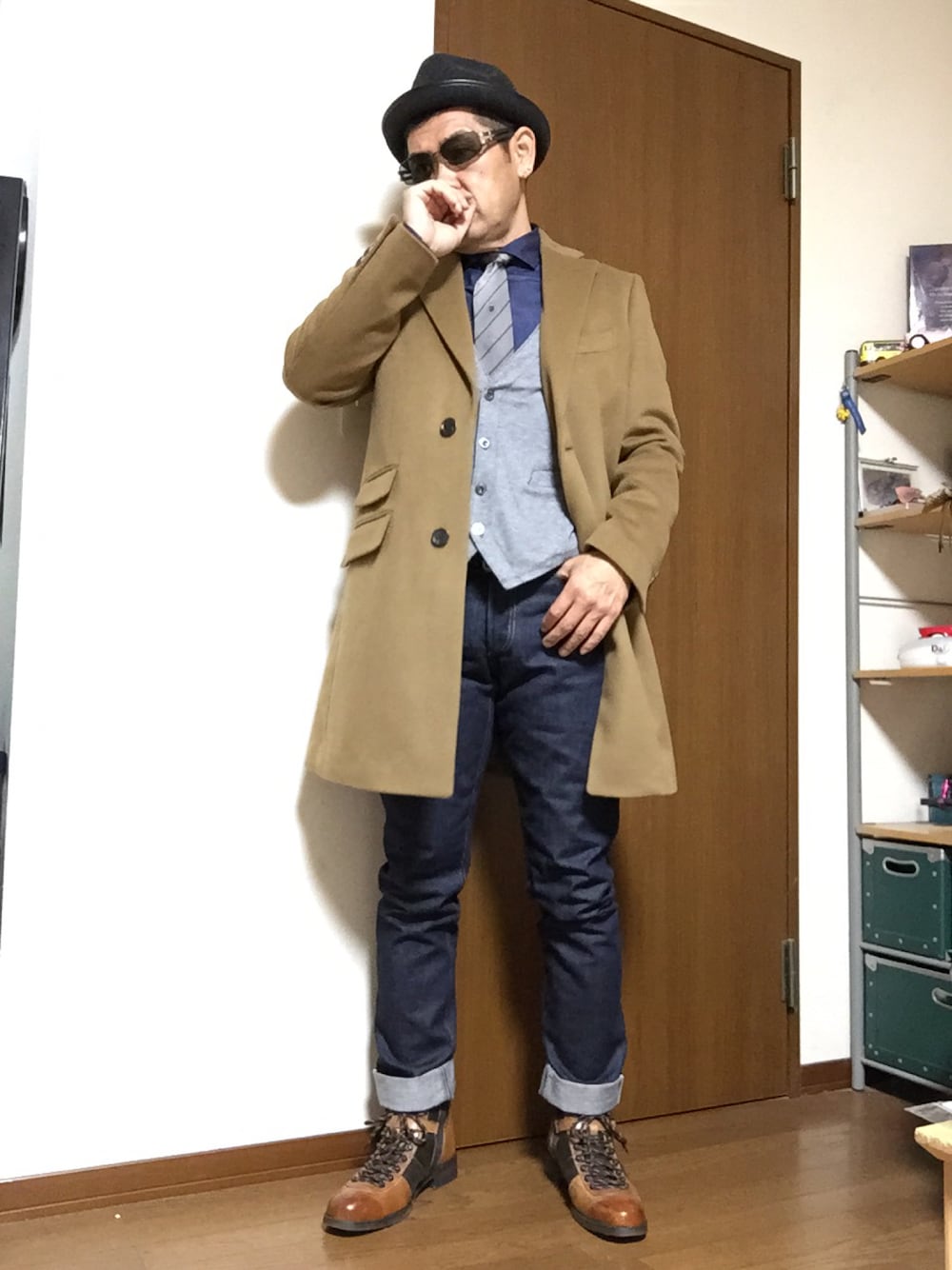 ベージュ系のチェスターコート、ブルー系のシャツ/ブラウス、グレー系のベストを着用したメンズの秋コーディネートの1枚目の写真