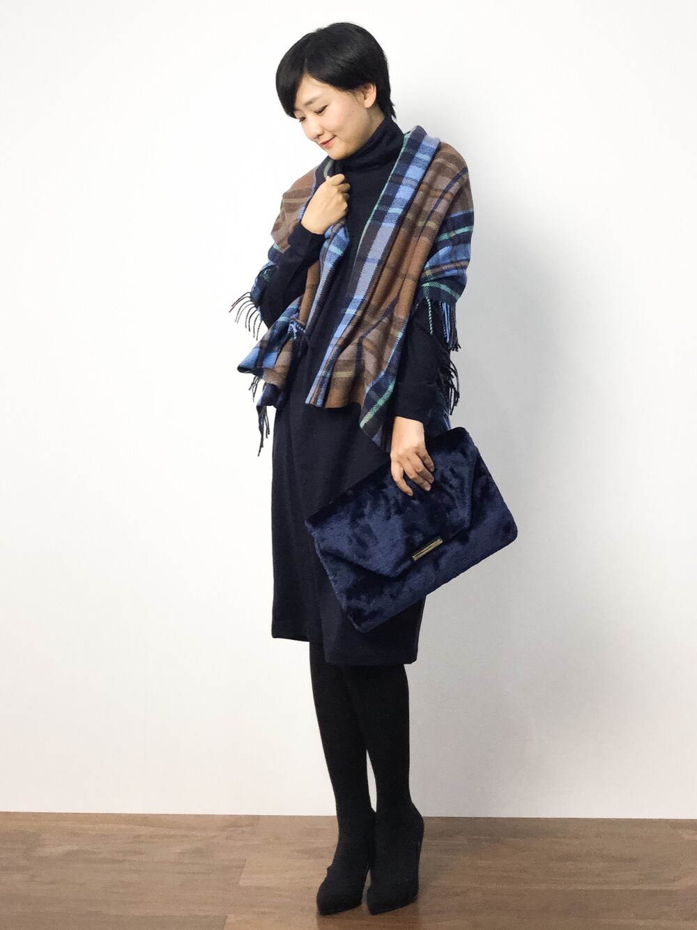 ブルー系のワンピース、ブルー系のクラッチバッグ、ブラック系のパンプスを着用したレディースの秋コーディネートの1枚目の写真