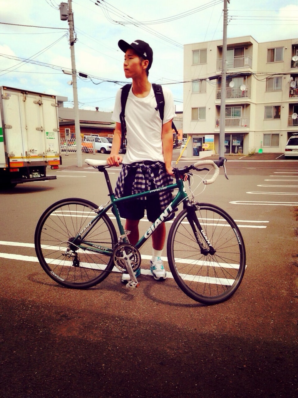 「ベースボールキャップ、腰巻きスタイル、自転車スタイル、無地T、NIKE AIR MAX、チェックシャツ、スポーツミックス、白ソックス」｜「UNIQLOのアイテム（Tシャツ/カットソー、ホワイト系）」を使った、おのだふなっしーたくみさん（メンズ・178cm）の夏コーディネートの1枚目の写真