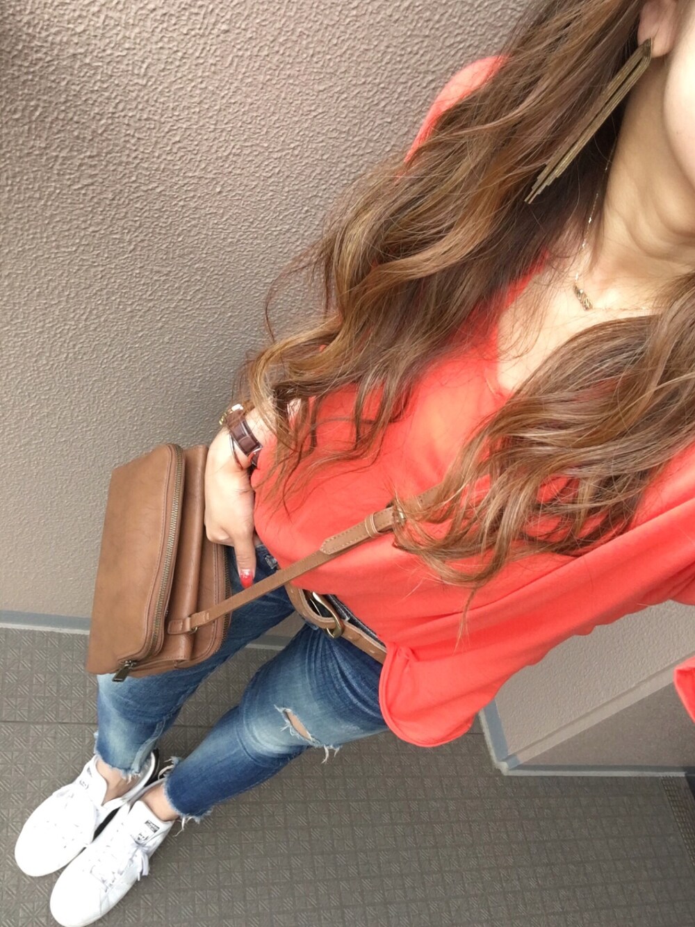 オレンジ系のTシャツ/カットソー、ブルー系のデニムパンツ、ブラウン系のショルダーバッグを着用したレディースの夏コーディネートの1枚目の写真