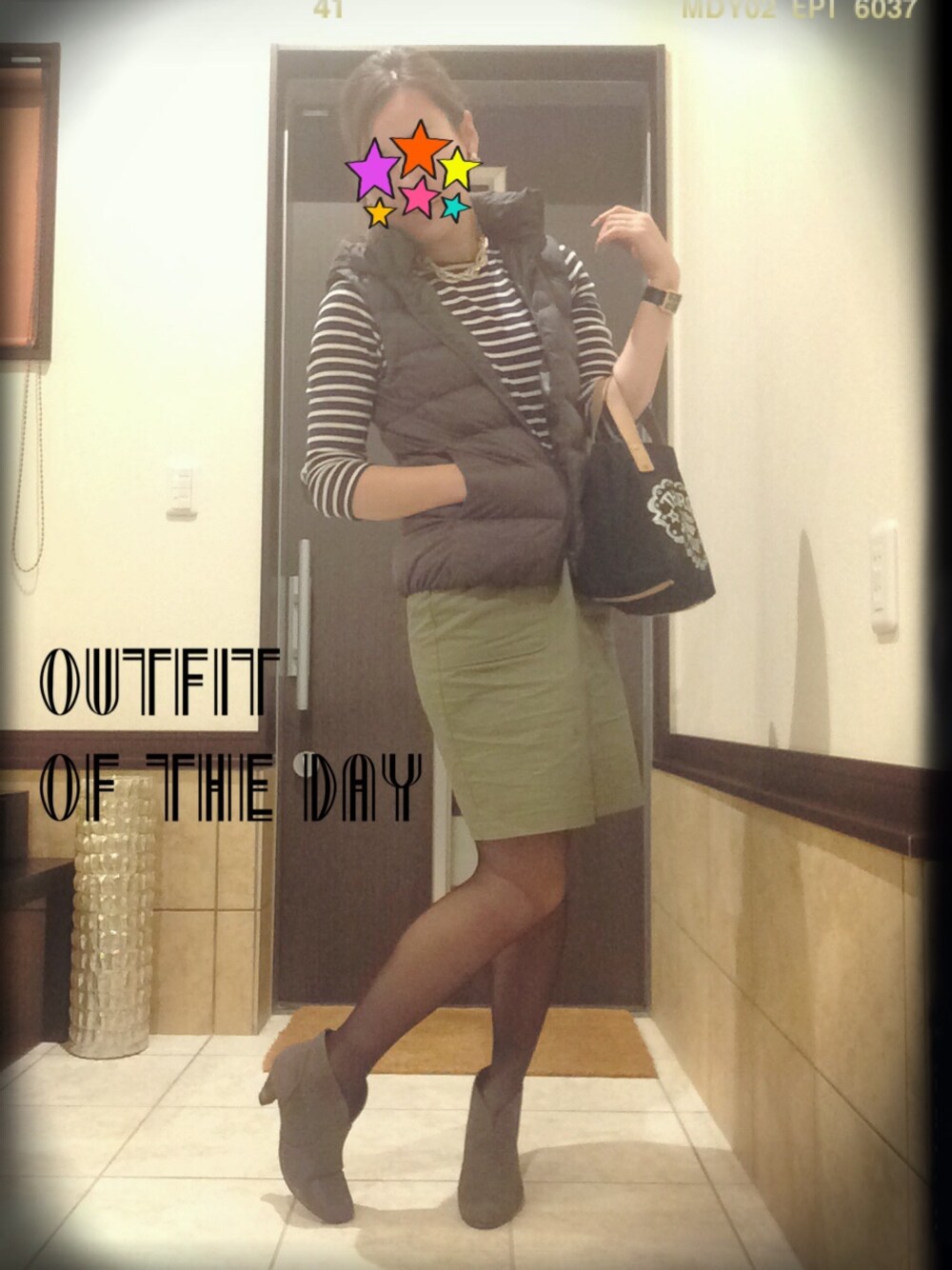 ブルー系のワンピース、グレー系のダウンベスト、グレー系のブーティを着用したレディースの秋コーディネートの1枚目の写真