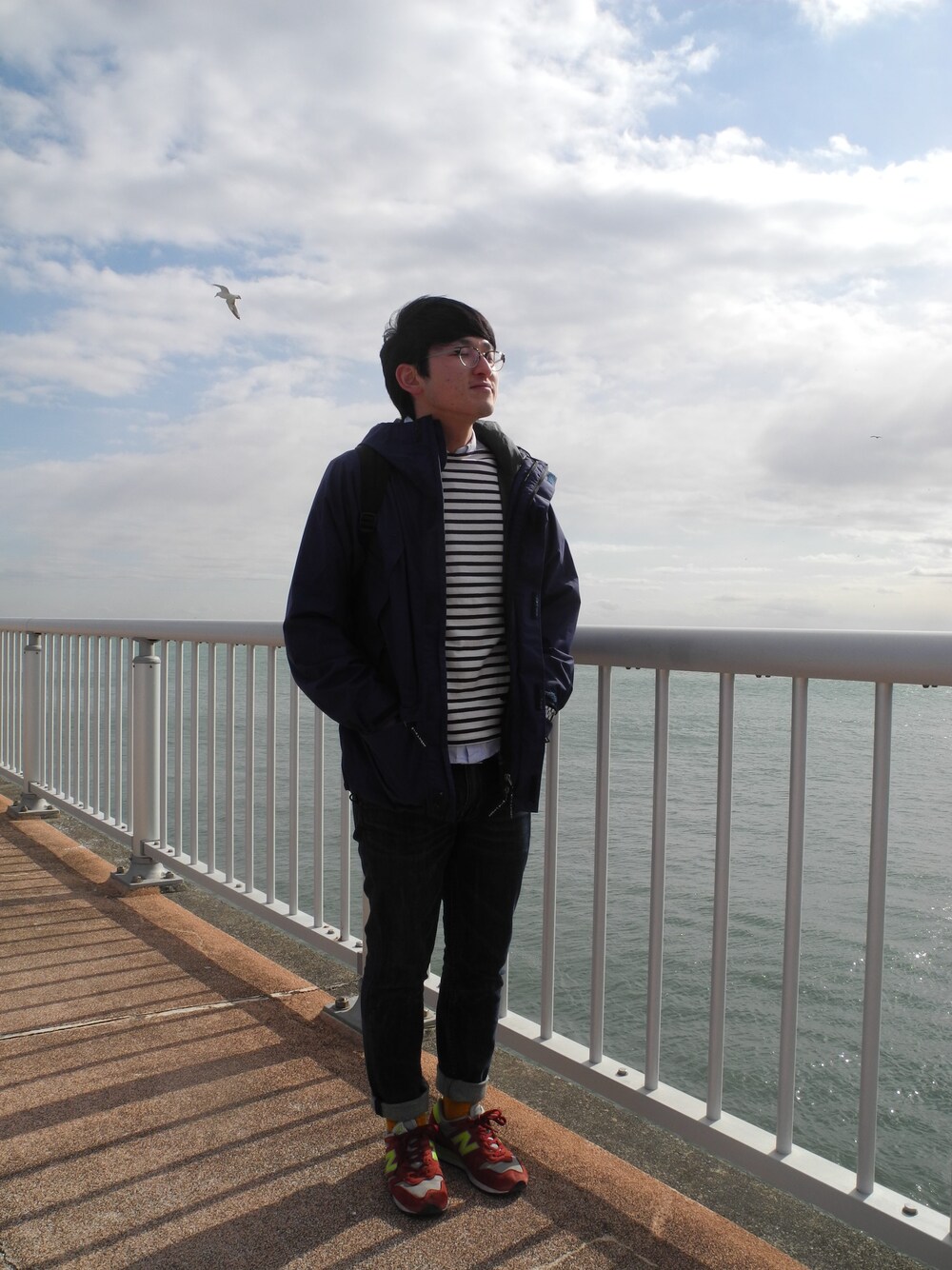 ベージュ系のTシャツ/カットソー、ブラック系のバックパック/リュック、ブラック系のダウンジャケット/コートを着用したメンズの冬コーディネートの1枚目の写真