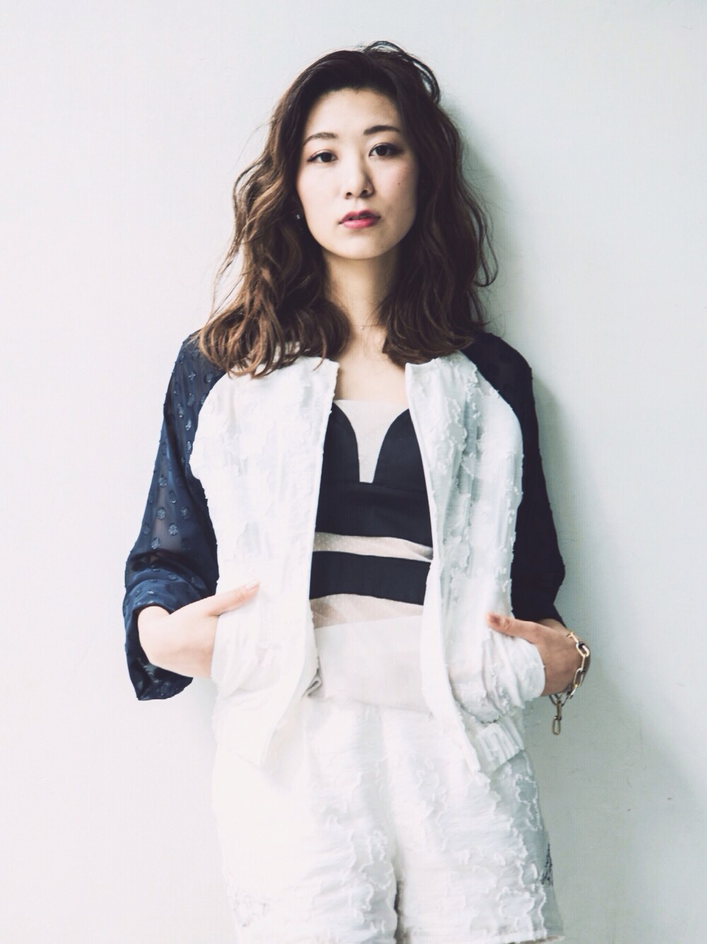 ホワイト系のその他パンツ、ブラック系のキャミソール、ホワイト系のブルゾンを着用したレディースの夏コーディネートの1枚目の写真