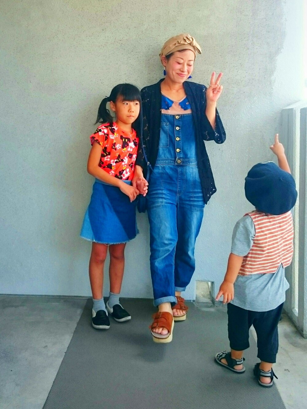 イエロー系のサンダル、ブルー系のデニムスカート、ベージュ系のTシャツ/カットソーを着用したレディースの夏コーディネートの1枚目の写真